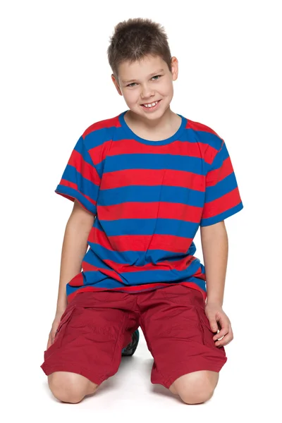 Улыбающийся мальчик в полосатой рубашке на белом — стоковое фото