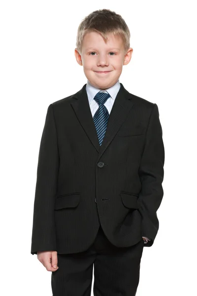 Красивый улыбающийся мальчик в черном костюме — стоковое фото