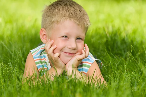 Boy imagines on the green grass — Stock Photo, Image