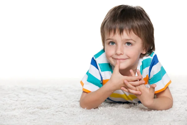 Drôle de garçon sur le tapis blanc — Photo