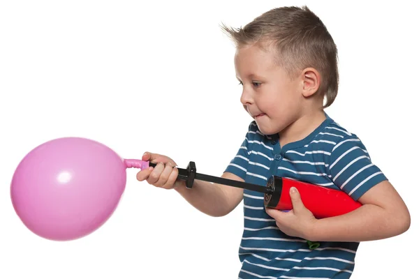 Little boy inflates a balloon Stock Photo