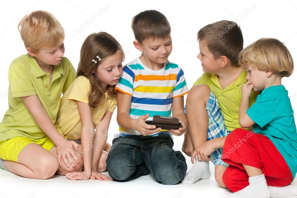 Group children plaing with a new gadget