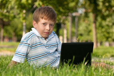 Çimlerin üstünde laptop ile çocuk