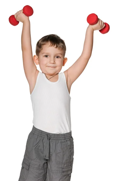 Boy do exercises with dumbbells — Stock Photo, Image