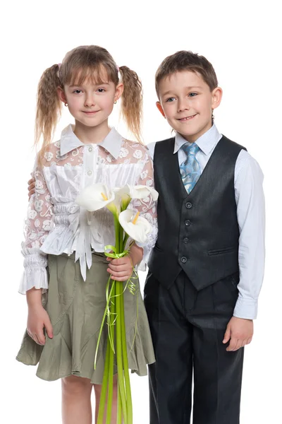 Schöner Junge und hübsches Mädchen mit Blumen — Stockfoto