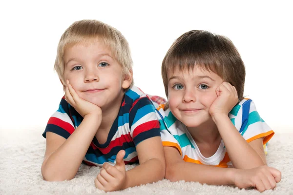 Two cheerful friends on the white carpet — Stock Photo, Image