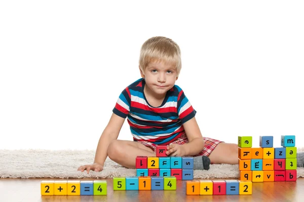 Nadenkend jongen met blokken op de verdieping — Stockfoto