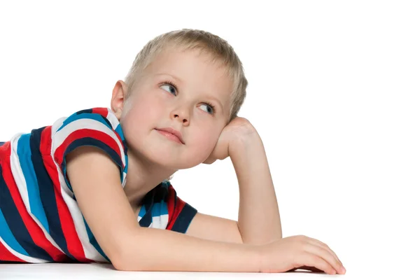 Träumender kleiner Junge auf dem weißen — Stockfoto