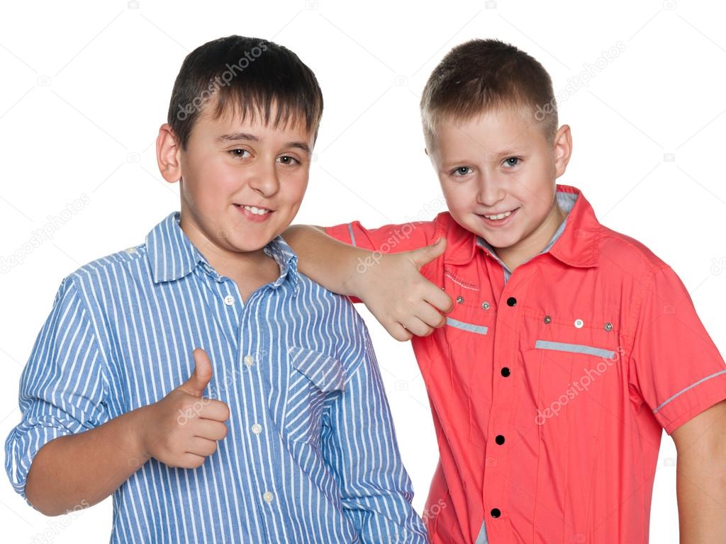 Two boys hold their thumbs up