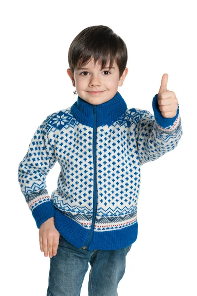 Niño en un suéter sostiene su pulgar hacia arriba —  Fotos de Stock