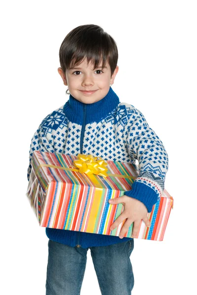 Young boy in a sweater holds a gift box — Stock Photo, Image