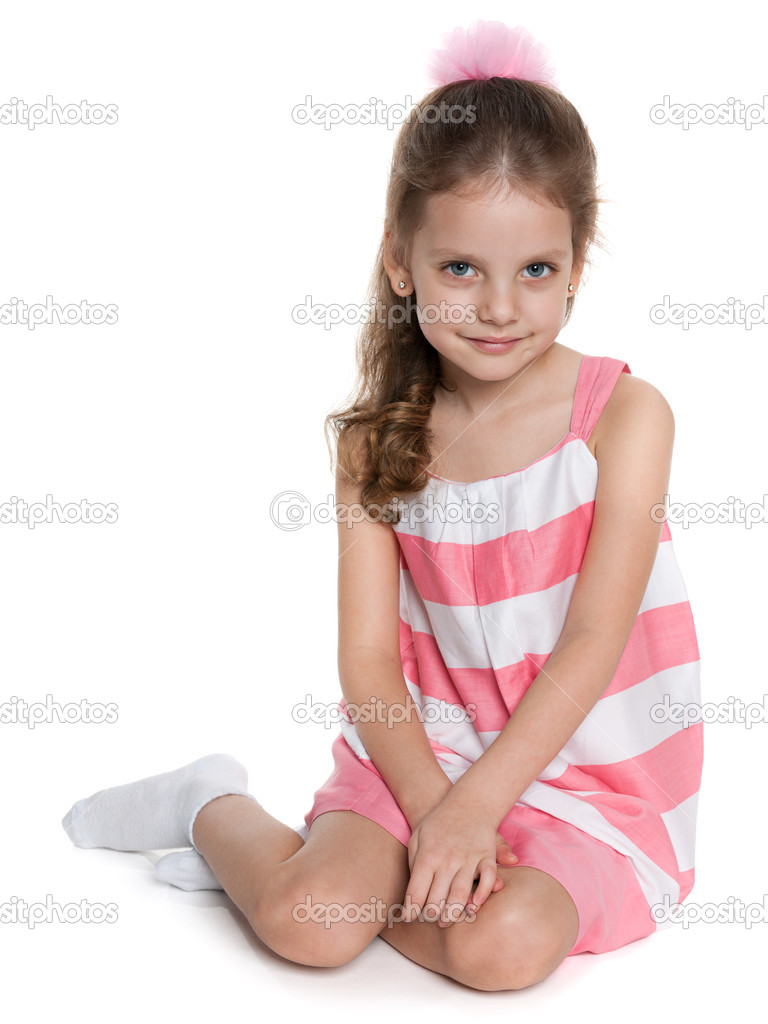 Portrait of a pretty girl sits against the white