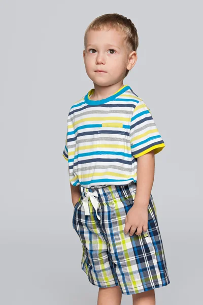 Розумний маленький хлопчик на сірому тлі — стокове фото