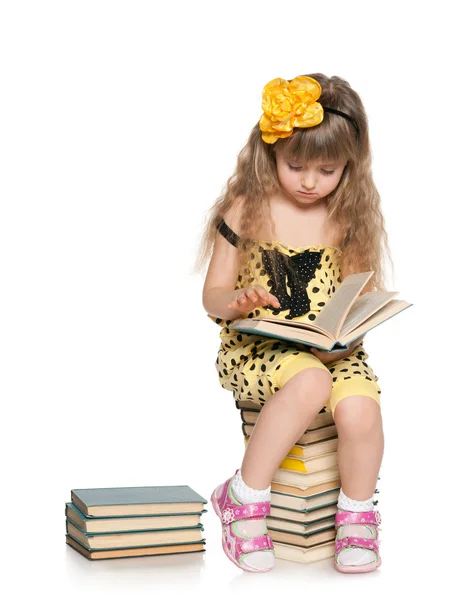 Chytrá dívka čte na hromadě knih — Stock fotografie
