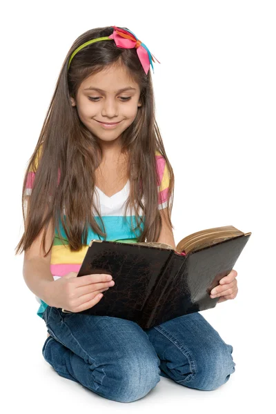 Smiling young girl reads an old book — Stock Photo, Image