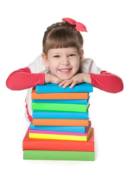 Lächelndes kleines Mädchen in der Nähe von Büchern — Stockfoto