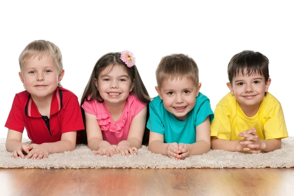 Quattro bambini sul tappeto bianco — Foto Stock