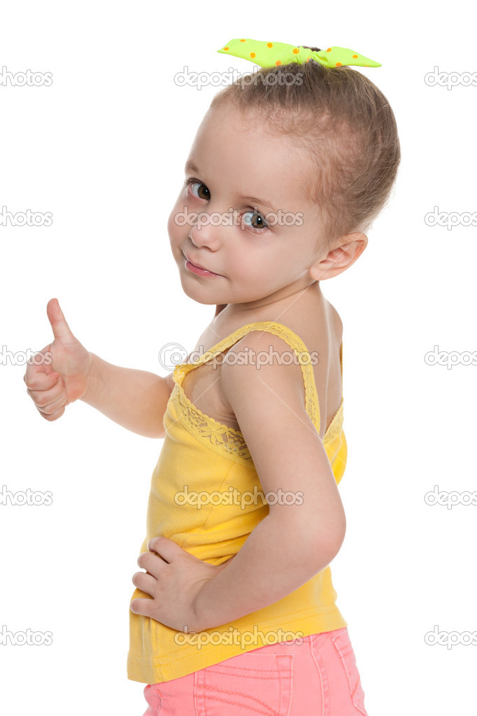 Little girl holds her thumbs up and looks back