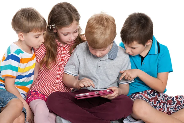 Grupo de niños trenzando con un gadget —  Fotos de Stock