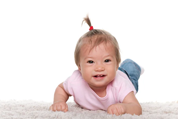 Gelukkig babymeisje op de witte loper — Stockfoto