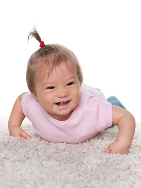 Ridere bambina sul tappeto bianco — Foto Stock