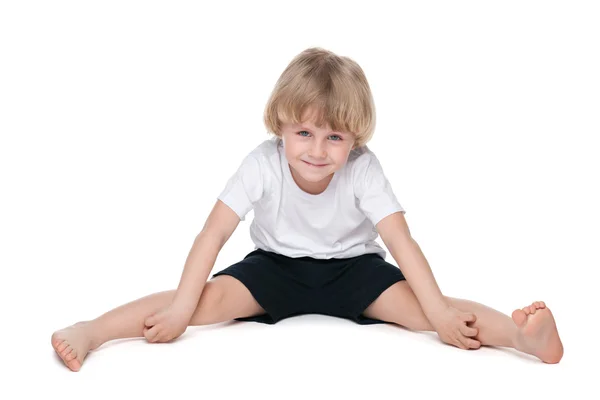 Kleine jongen voert gymnastische oefeningen — Stockfoto