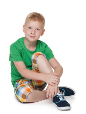 Yeşil tişörtlü dalgın küçük çocuk