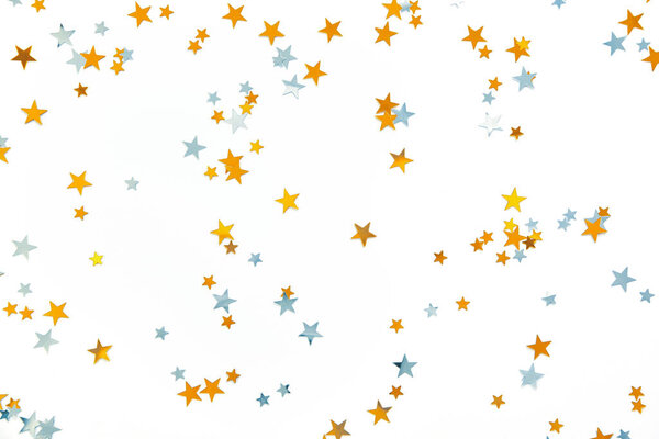 Золотые и серебряные звезды, праздничные конфетти на белом фоне