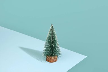 Mavi arka planda küçük bir Noel ağacı.
