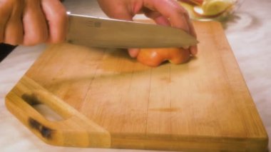 Kadın eli, mutfak tahtasındaki bıçakla sulu bir elmayı keser..