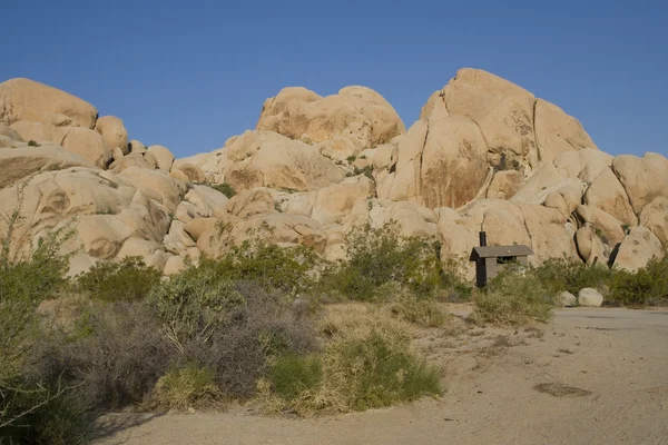 Los baños públicos se sientan entre rocas de granito en el Parque Nacional Joshua Tree (Indian Cove Campground ) Imagen De Stock