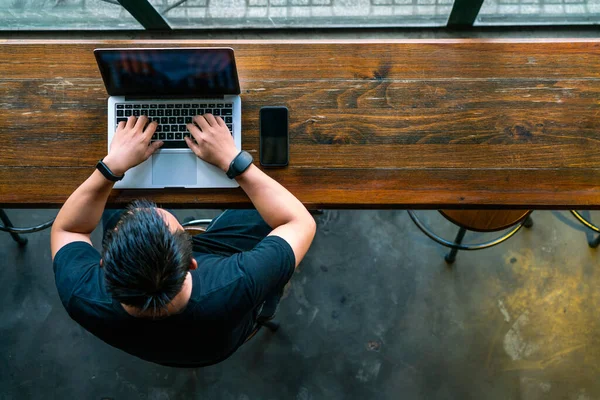 Fiatal ázsiai üzletember használ laptop fa asztalon — Stock Fotó