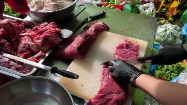 야외 시장에서 쇠고기 측면 고기를 자르고 있는 여성 4K 장면 — 비디오
