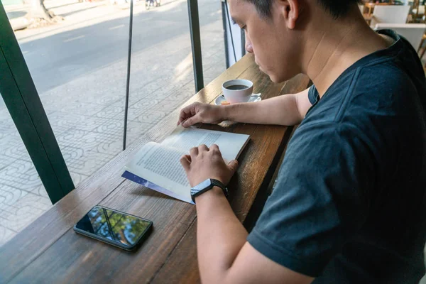 Fiatal férfi diák olvasás könyv egy kávézóban — Stock Fotó
