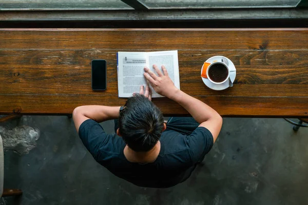 Mężczyzna czyta książki i pije kawę rano — Zdjęcie stockowe