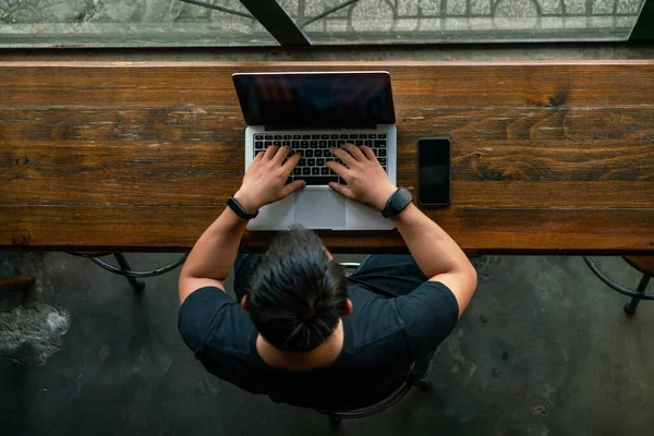 Egy férfi két okos órát visel és laptopot használ. — Stock Fotó