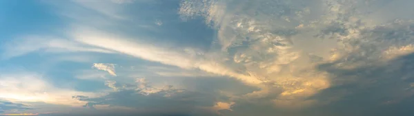 戏剧化的蓝天和美丽的落日下的云彩构成的全景 免版税图库图片