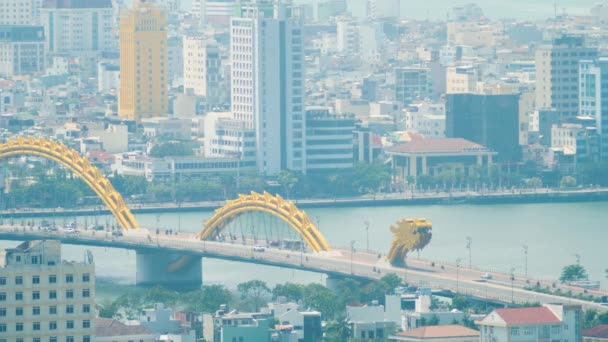 Real time shot of Dragon Bridge w DaNang Wietnam z poruszających się pojazdów i budynków w tle. — Wideo stockowe