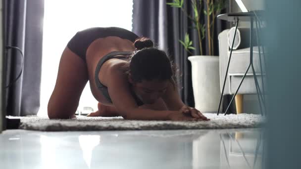 Μια έγκυος γυναίκα στο τρίτο τρίμηνο της κάνοντας γιόγκα γυμνάζεται στο πάτωμα στο σπίτι — Αρχείο Βίντεο
