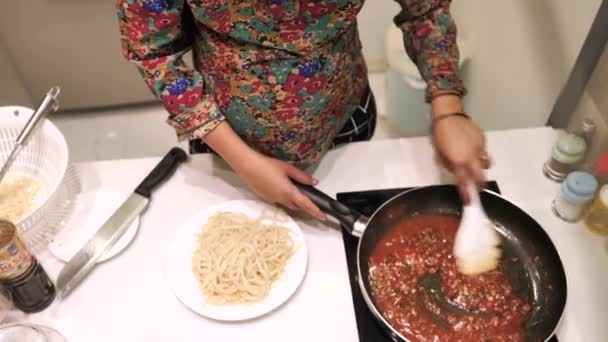 Una mujer embarazada preparando pasta con salsa roja en la cocina. — Vídeo de stock