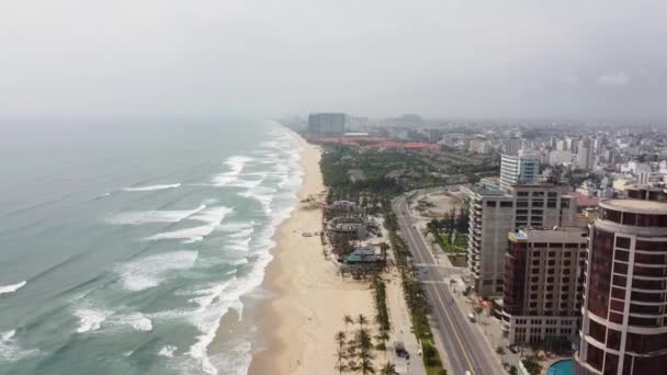 Luftaufnahme einer schönen und ruhigen Stadt mit großen Gebäuden und langem weißen Sandstrand. — Stockvideo