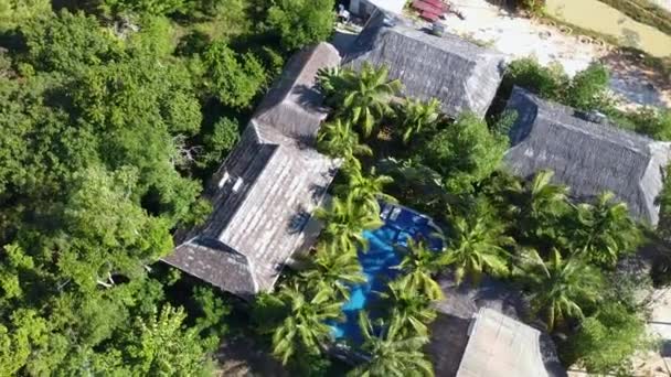 Widok z lotu ptaka na hotel z basenem, wokół palm i budynku hotelu — Wideo stockowe