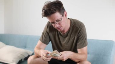 Parlak bir odada erkeklerin elleri para ve diğer para birimlerini sayar.