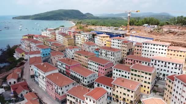Luchtfoto van een nieuw gebied in de stad, nieuwe huizen met appartementen voor mensen in de buurt van de zee en een resort in de buurt van de oceaan in Azië — Stockvideo