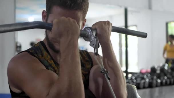 A Young European Man Is Doing Sports in the Gym, Doing Biceps Exercises (dalam bahasa Inggris). — Stok Video