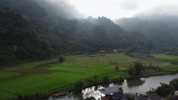 Vue Aérienne D'un Village Asiatique Dans Les Montagnes, Un Grand Brouillard Gris Et Une Vue Sur La Rivière, Autour D'une Forêt Verte — Video