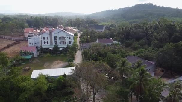 Vista aérea de uma grande floresta verde com palmeiras e um edifício residencial com piscina e hotéis — Vídeo de Stock
