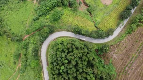 Letecký pohled na cestu mezi horami, kolem lesů a džunglí, motocyklistů a automobilů na silnici — Stock video