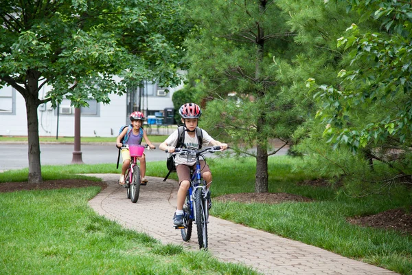 Niños yendo en bicicleta a la escuela — Foto de Stock