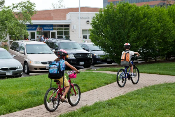 Niños yendo en bicicleta a la escuela — Foto de Stock